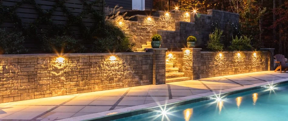 Retaining wall with steps and lighting near a pool in New Light, NC.
